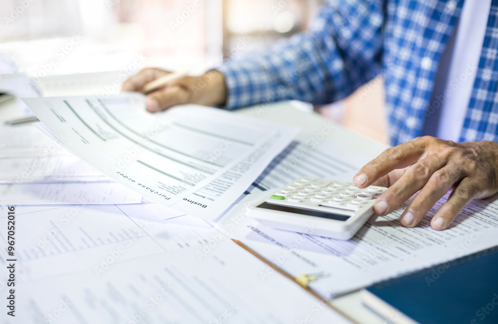 Asian man doing online business calculate income and expenses from purchase order, checking financial document after start new business owner Asian man doing online business calculate income and expenses from purchase order, checking financial document after start new business owner