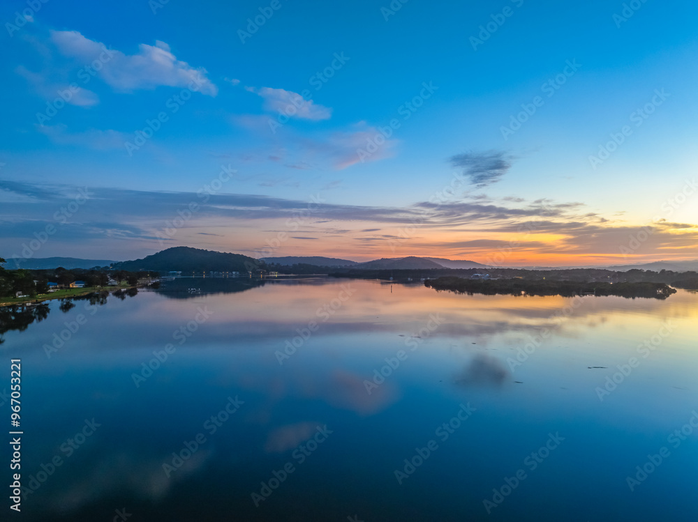 Sunrise along the waterfront with reflections on the bay water Sunrise along the waterfront with reflections on the bay water