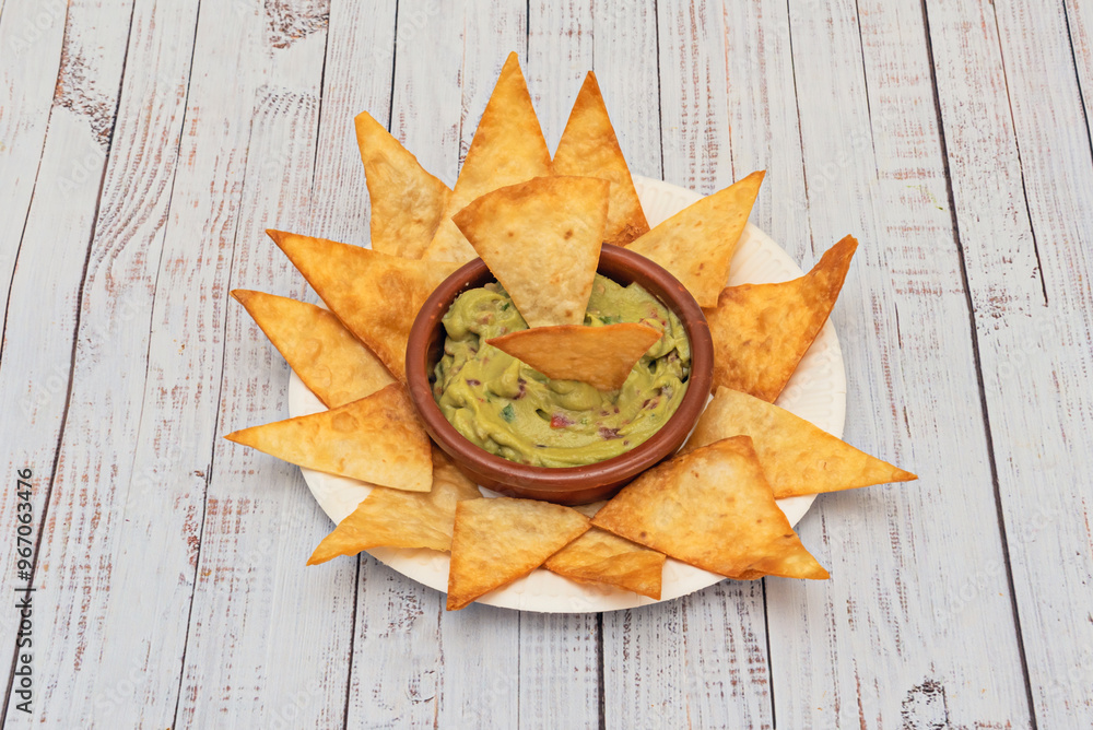 A delicious Mexican-style appetizer with a side of guacamole and nachos A delicious Mexican-style appetizer with a side of guacamole and nachos