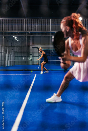Quadro su tela Through the net shot of a doubles female padel match