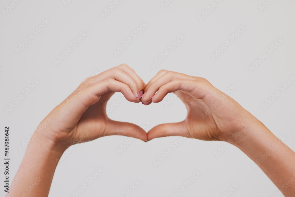 Fototapeta premium Closeup, heart or hands in studio for love, charity or health insurance isolated on gray background. Peace, fingers or woman with sign for romance, care or show emoji gesture for kindness or donation
