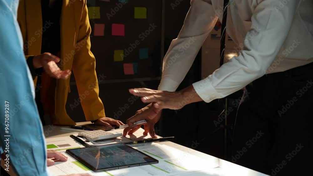 Group of Asian business men and women point to graphs and charts, management, personnel, employees to analyze market data, balance sheets, accounting, taxes to plan online sales strategies. Group of Asian business men and women point to graphs and charts, management, personnel, employees to analyze market data, balance sheets, accounting, taxes to plan online sales strategies.