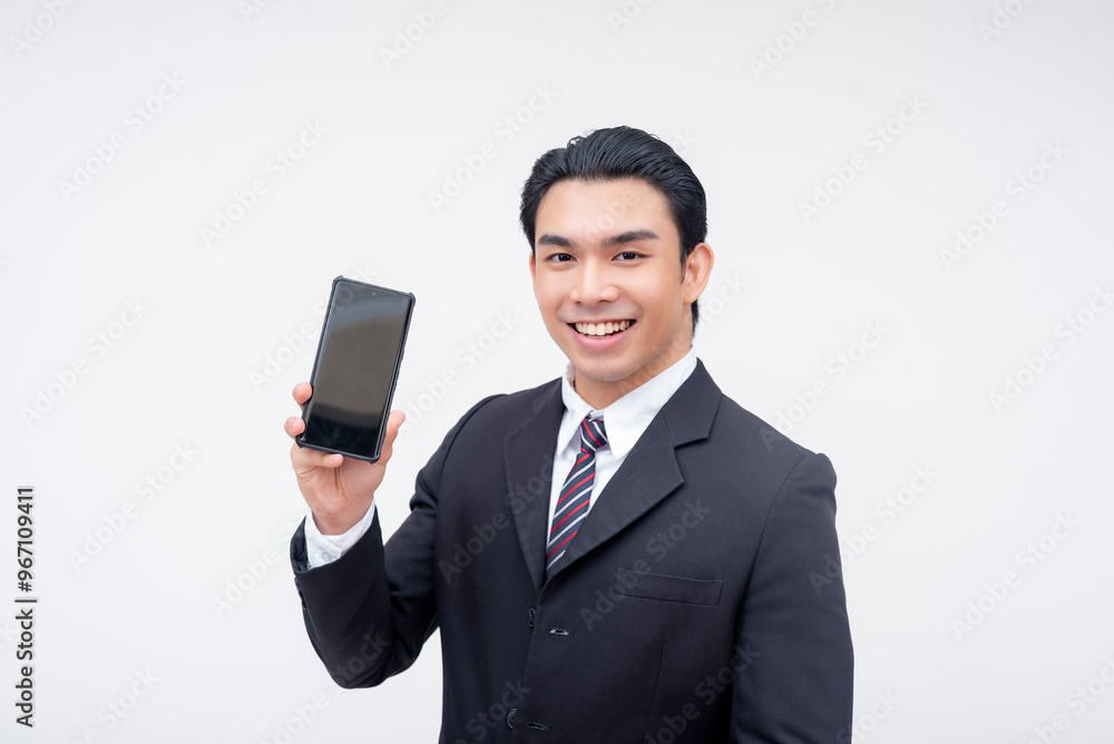 A young asian business executive holding a cellphone and smiling. Promoting a phone app. Isolated on a white background. A young asian business executive holding a cellphone and smiling. Promoting a phone app. Isolated on a white background.