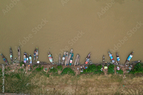 Busy Riverbank with Boats Docked and People Engaging in Daily Activities photo