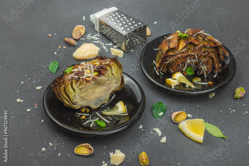 Delicious baked artichoke with parmesan cheese and pistachio. Olive oil, garlic, parsley and lemon photo