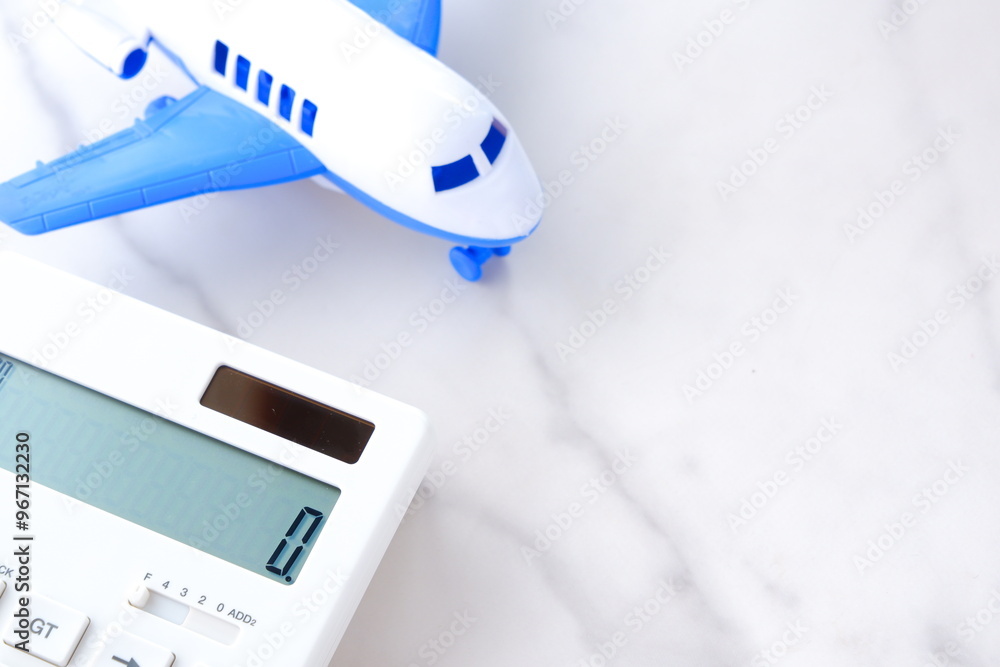 電卓と飛行機で、高騰する航空券代と、高騰する旅行代金のイメージ
電卓と飛行機で、高騰する航空券代と、高騰する旅行代金のイメージ