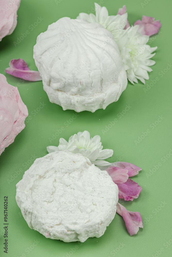 Fruit marshmallow with fresh flower petals on pastel green background. Lactose free vegan dessert Fruit marshmallow with fresh flower petals on pastel green background. Lactose free vegan dessert