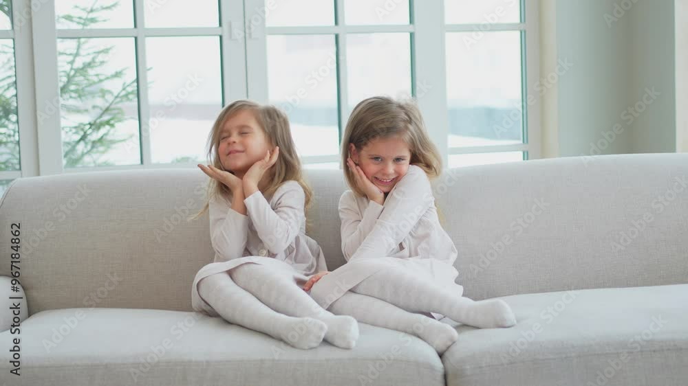 Happy family sisterly love. Two funny little twin sisters girls smiling playing together at home indoors. Happy children lifestyle. Identical twin girls. Girls friendship and youth