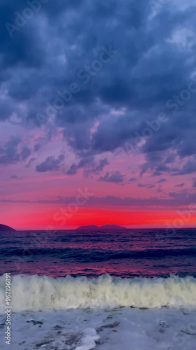 Scenic view of waves rushing at sandy beach against sky during sunset