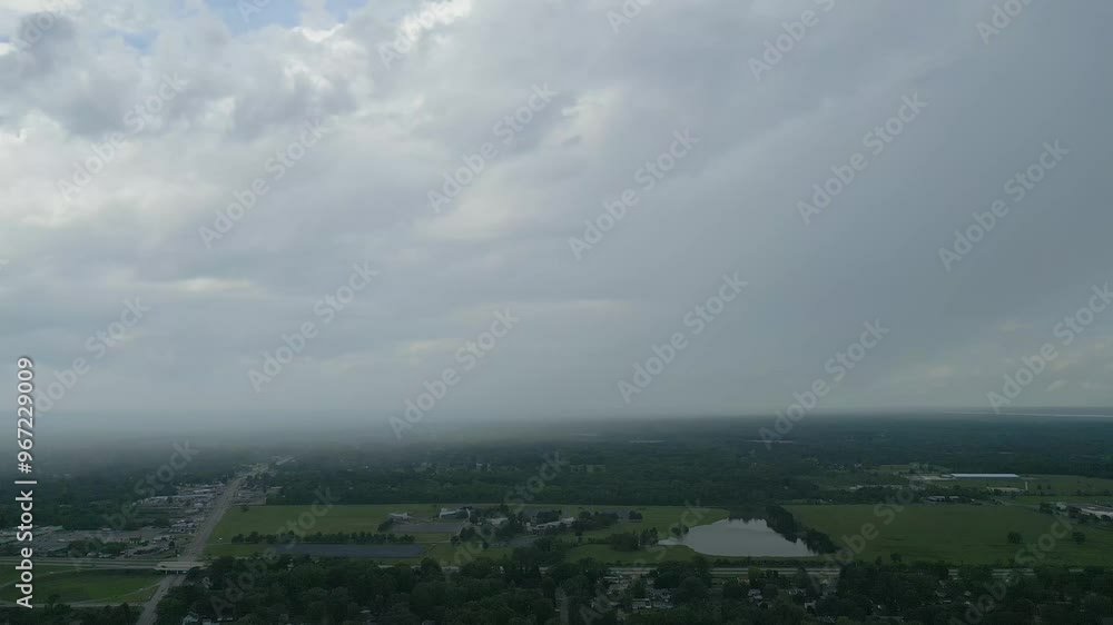 A serene aerial view of a vast green landscape under a cloudy sky. The misty horizon blends seamlessly with the rolling clouds, evoking a calm yet mysterious atmosphere. A serene aerial view of a vast green landscape under a cloudy sky. The misty horizon blends seamlessly with the rolling clouds, evoking a calm yet mysterious atmosphere.