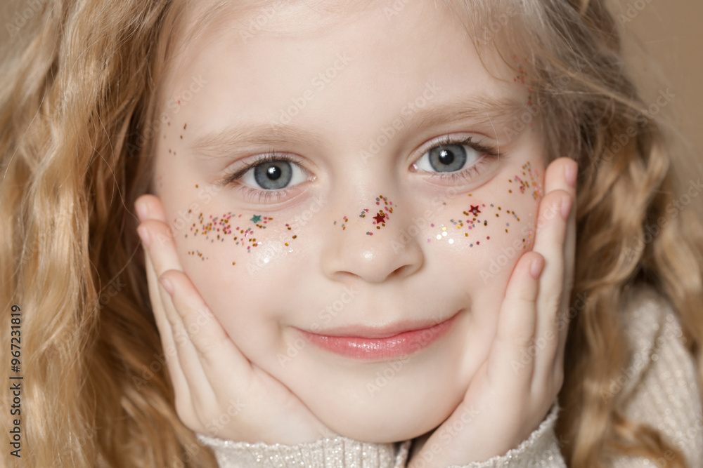 Portrait of cute little blonde girl with blue eyes and glitters on her face. Portrait of cute little blonde girl with blue eyes and glitters on her face.