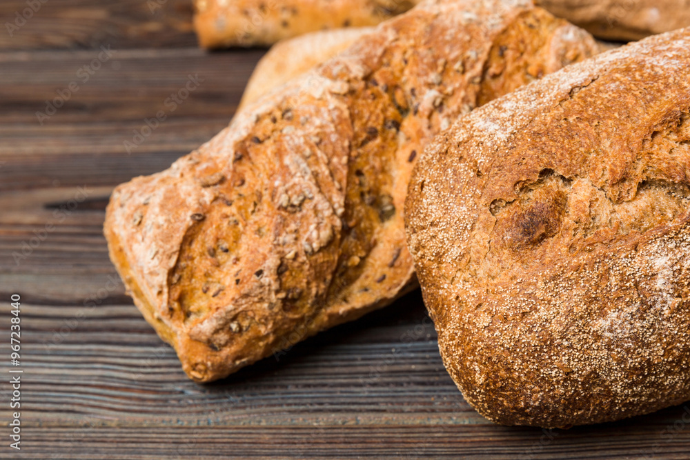 Fototapeta premium Homemade natural breads. Different kinds of fresh bread as background, perspective view with copy space