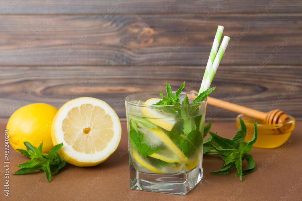 Fototapeta premium Mojito cocktail. Refreshing mojito cocktail with lime, lemon and mint in a tall glass with a stick