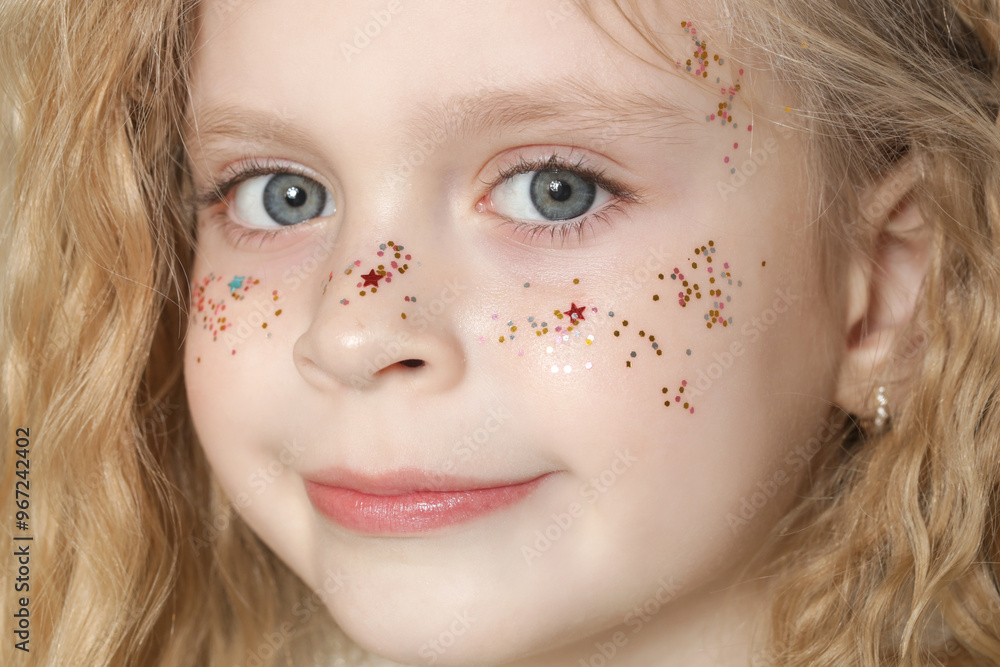 Φωτογραφία Portrait of cute little blonde girl with blue eyes and glitters on her face