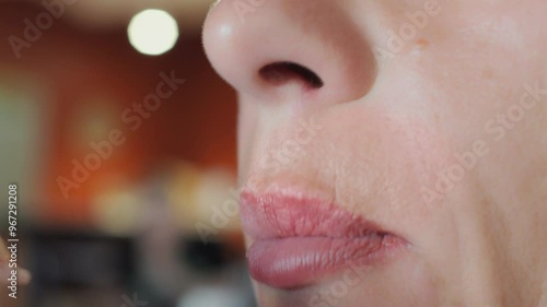 Close-up of lips and mouth of a woman eating pizza in a restaurant. Happy woman putting food in her mouth and chewing.