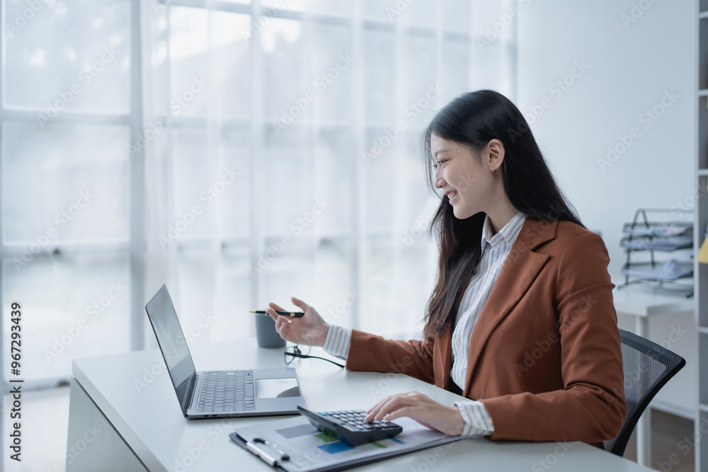 woman meticulously plans a finance audit, using a computer and calculator to review budget documents and ensure accuracy woman meticulously plans a finance audit, using a computer and calculator to review budget documents and ensure accuracy