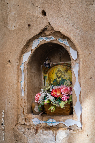 Petite alcove dans un mur avec une image et des fleurs