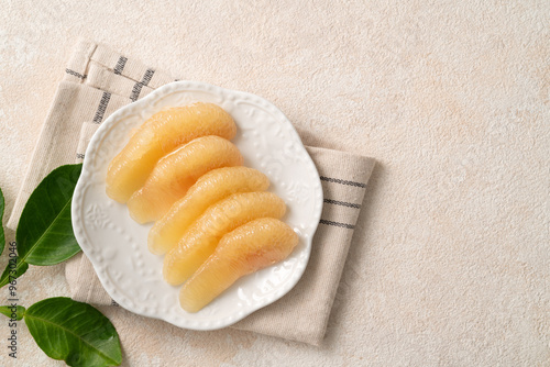 Fresh pomelo fruit with leaf on white table background.