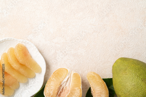 Fresh pomelo fruit with leaf on white table background.