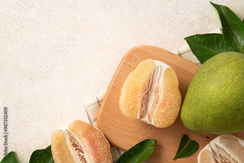 Fresh pomelo fruit with leaf on white table background.