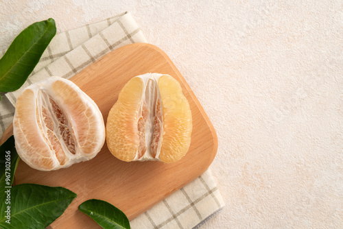 Fresh pomelo fruit with leaf on white table background.