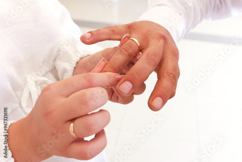 The bride puts a gold wedding ring on the groom's finger. Wedding ceremony.