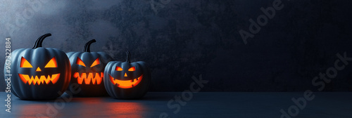 Three Halloween pumpkins with spooky carved faces stand aligned to the left side, copi space photo