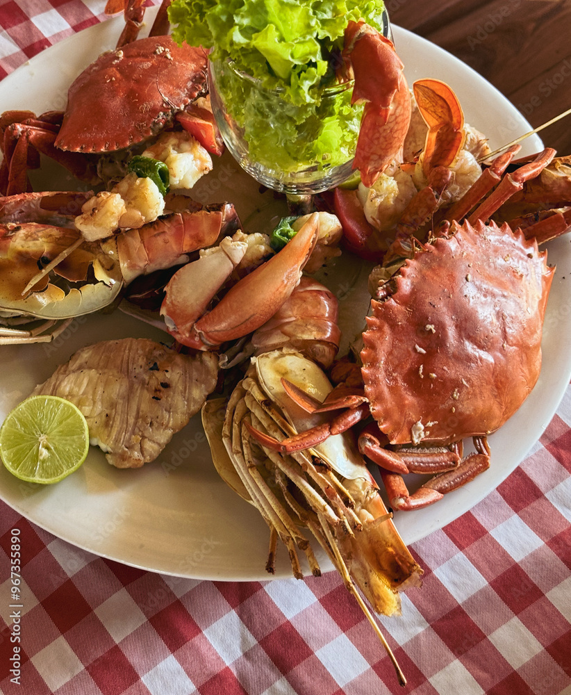 Delicious seafood platter featuring fresh crabs and shrimp from Madagascar served on a vibrant checkered tablecloth during a sunny afternoon Delicious seafood platter featuring fresh crabs and shrimp from Madagascar served on a vibrant checkered tablecloth during a sunny afternoon