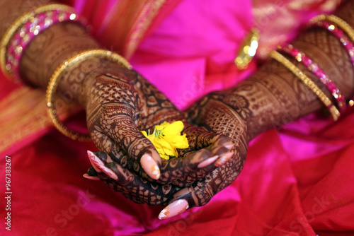 A beautiful bridal hand featuring intricate henna designs. The rich, dark henna contrasts elegantly against the bride's skin, symbolizing love, joy, and the auspiciousness of the wedding ceremony. photo