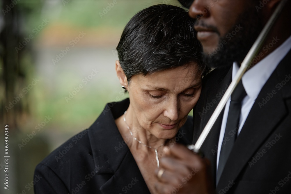 Portrait of sorrowful senior woman grieving over loss of loved one leaning on comforting man during memorial ceremony at gravesite, copy space Portrait of sorrowful senior woman grieving over loss of loved one leaning on comforting man during memorial ceremony at gravesite, copy space