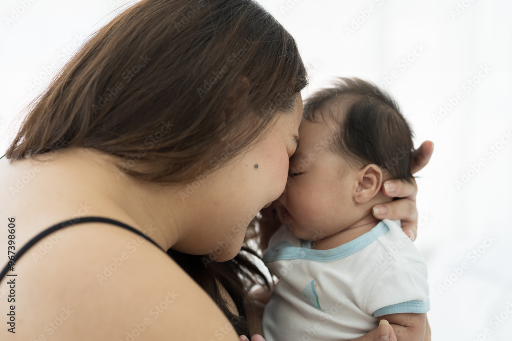 Asian plus size mother embracing and carrying her newborn baby at home Asian plus size mother embracing and carrying her newborn baby at home