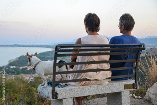 Sunset Reflections: Elderly Couple and Jack Russell on a Bench by the Bay photo