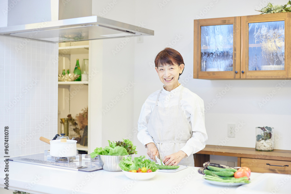 キッチンにて料理をするエプロンを着た日本人シニア女性 キッチンにて料理をするエプロンを着た日本人シニア女性