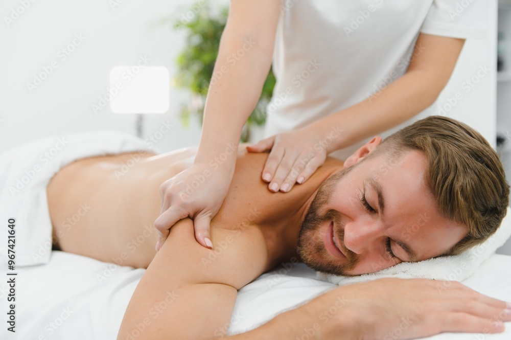 Handsome middle-aged man enjoying relaxing spa massage with oils Handsome middle-aged man enjoying relaxing spa massage with oils