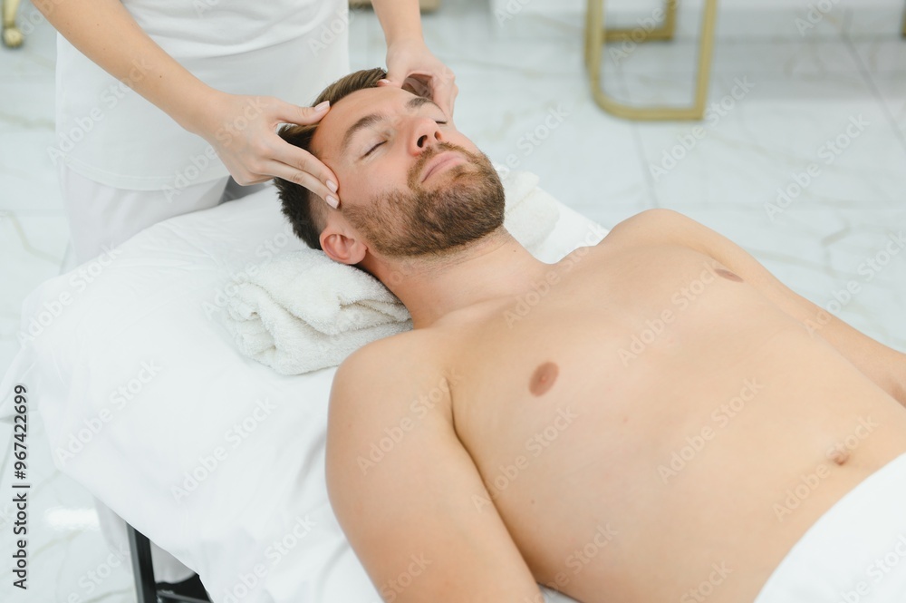 Obraz premium Handsome middle-aged man enjoying relaxing spa massage with oils