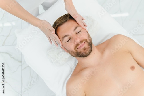 Relaxing anti stress head massage. Handsome man relaxes in a massage parlor during head massage