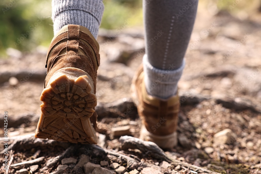 Young hiker in trekking shoes walking outdoors, closeup Young hiker in trekking shoes walking outdoors, closeup