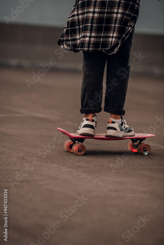 Teenage skateboarder riding a board in jeans and sneakers