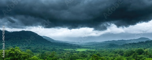 Dense monsoon clouds layered over a tropical forest, obscured valleys hidden beneath a heavy downpour, deep greens and grays dominate the scene