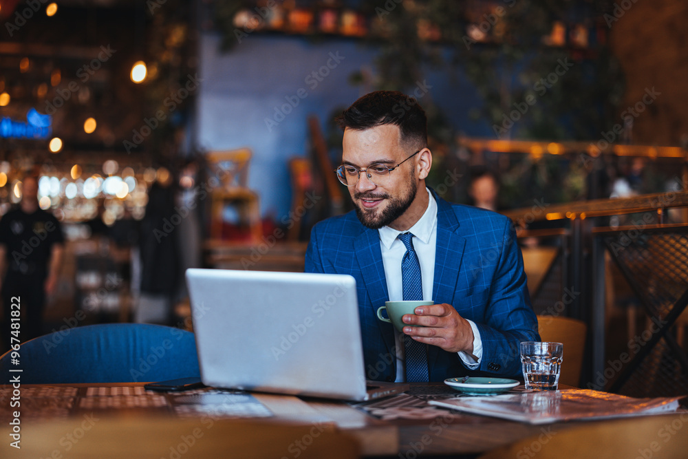Businessman Enjoying Coffee While Working on Laptop in Cafe Businessman Enjoying Coffee While Working on Laptop in Cafe