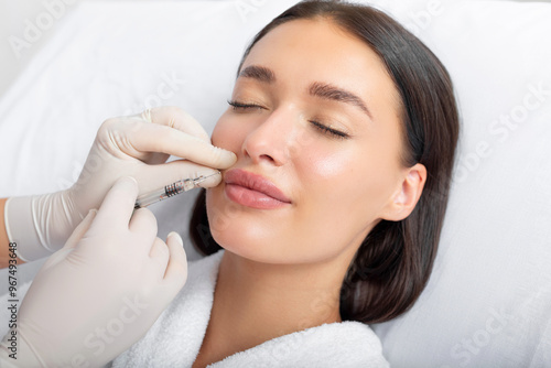 Fotografia Beauty specialist making injection in female patient lips, lip augmentation and
