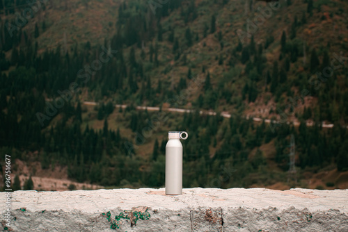 Thermos bottle in Autumn mountains on the background. Kazakhstan, Almaty, Medeo photo