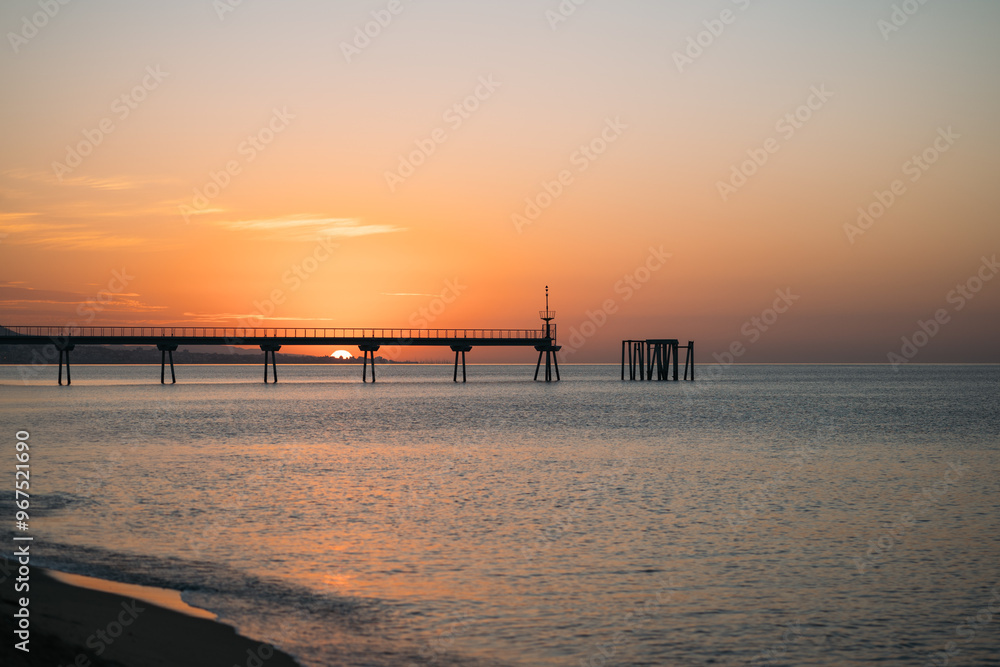Enjoy the breathtaking view of the stunning sunset at a picturesque coastal pier located in beautiful Barcelona Enjoy the breathtaking view of the stunning sunset at a picturesque coastal pier located in beautiful Barcelona