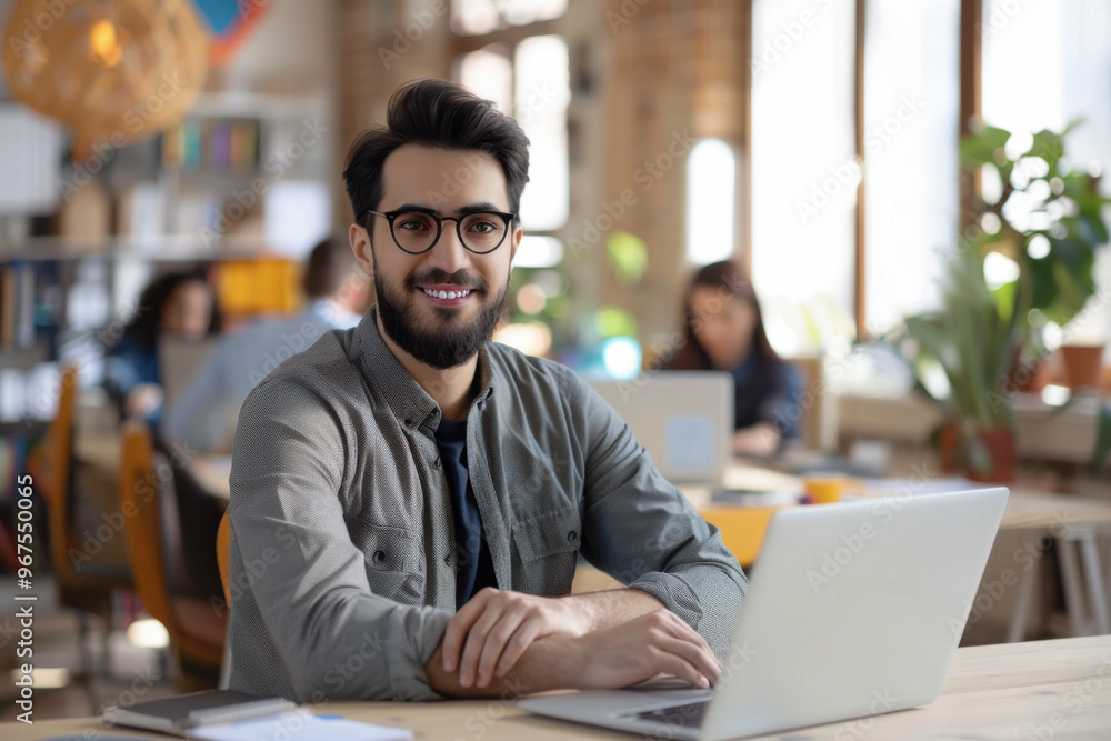 Photo of happy cheerful coder looking at camera, web designing indoors at modern bright workplace, workstation or loft Photo of happy cheerful coder looking at camera, web designing indoors at modern bright workplace, workstation or loft