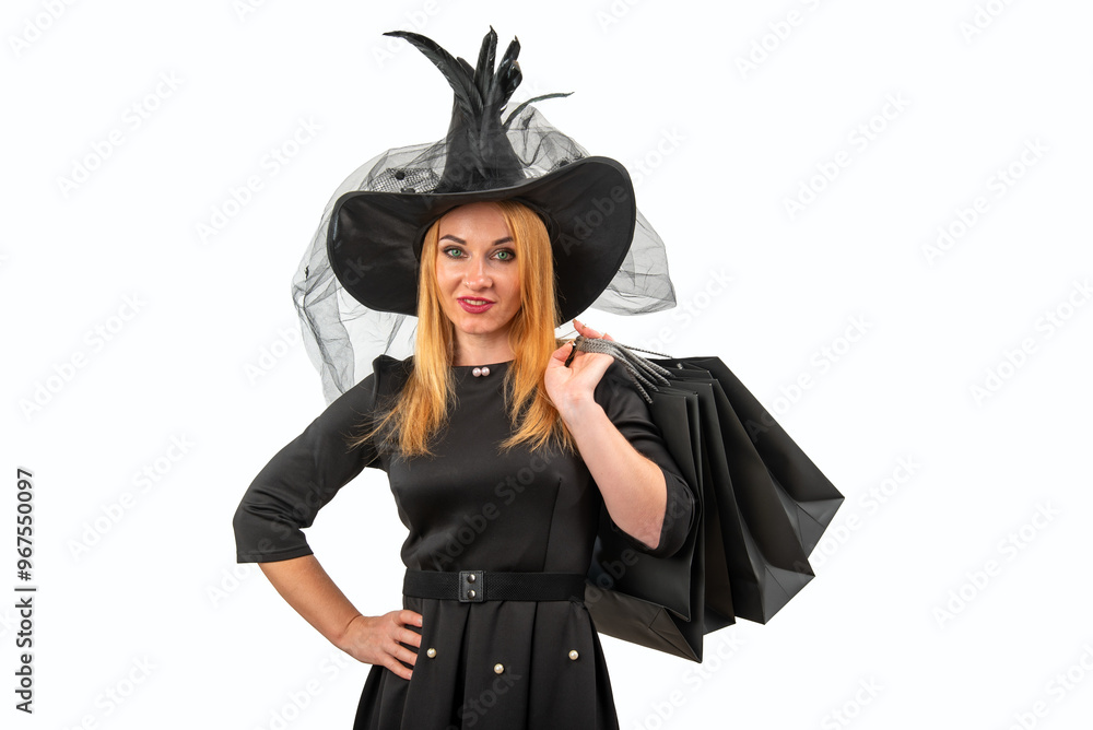 Fototapeta premium Smiling woman wearing witch costume posing with hand on hip holding black shopping bags