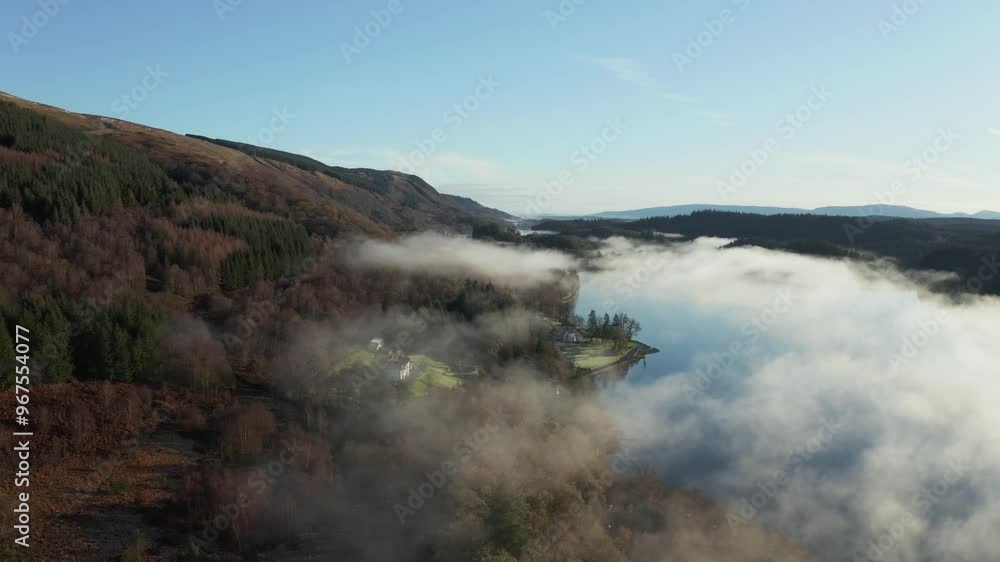 Aerial view of tranquil Loch Ard surrounded by serene forest and misty hills, Aberlour, United Kingdom. Aerial view of tranquil Loch Ard surrounded by serene forest and misty hills, Aberlour, United Kingdom.