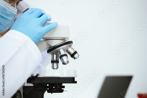 Medical laboratory scientists analyze DNA and chemical samples using advanced equipment such as microscopes and pipettes. Biotechnology and healthcare developments photo