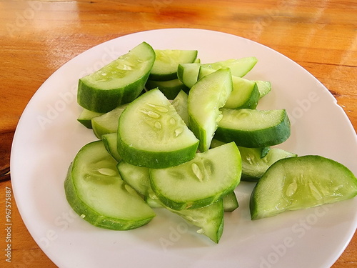 Cucumbers are cut into bite-sized pieces for side dish. Cucumbers are placed on a white plate for eat with single dish or dip with spicy chili paste. The fruit helps quench thirst, reduce body heat,
