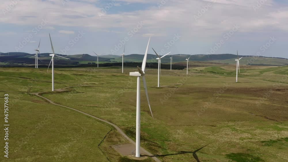 Aerial view of a beautiful wind farm with numerous wind turbines in a vast green landscape, Biggar, Scotland, United Kingdom. Aerial view of a beautiful wind farm with numerous wind turbines in a vast green landscape, Biggar, Scotland, United Kingdom.