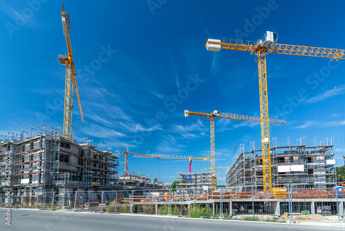 Large construction site with several cranes, foundations and buildings